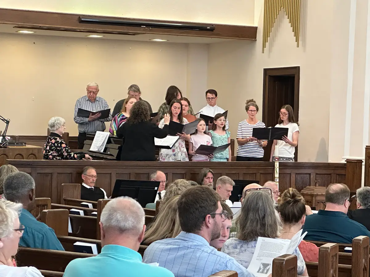 The Monroe choir singing at the front of the sanctuary during worship.