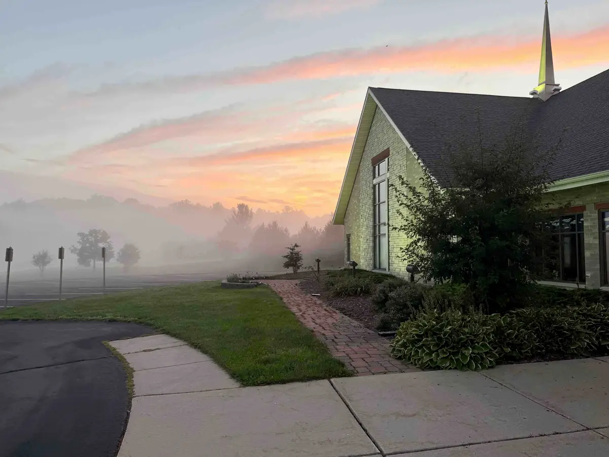 The Verona campus at dawn, with ground fog across the lawn.