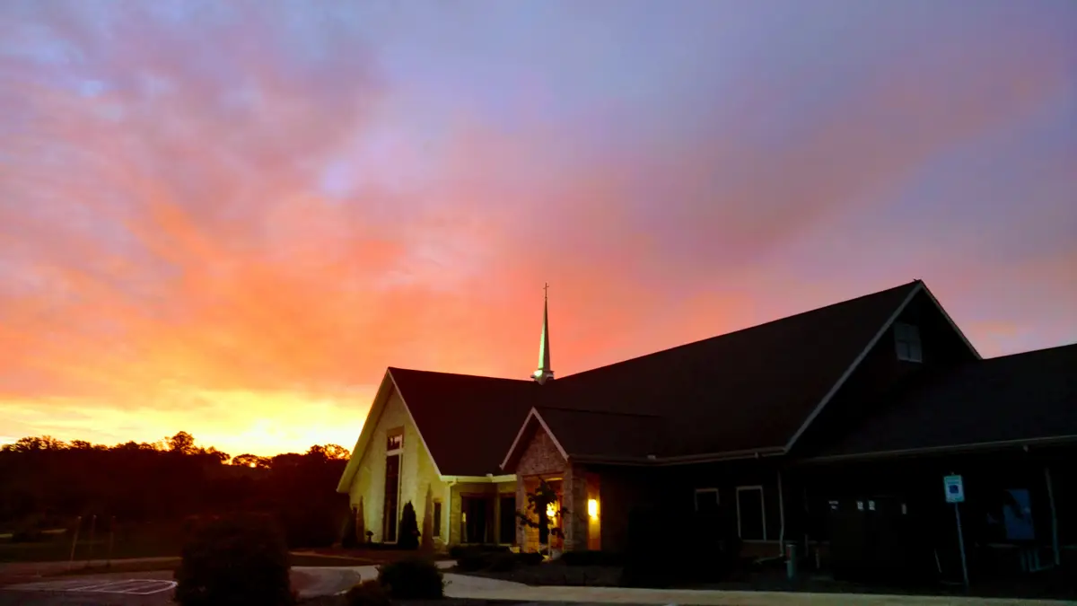 The Verona campus silhouetted against an orange and violet sunset.