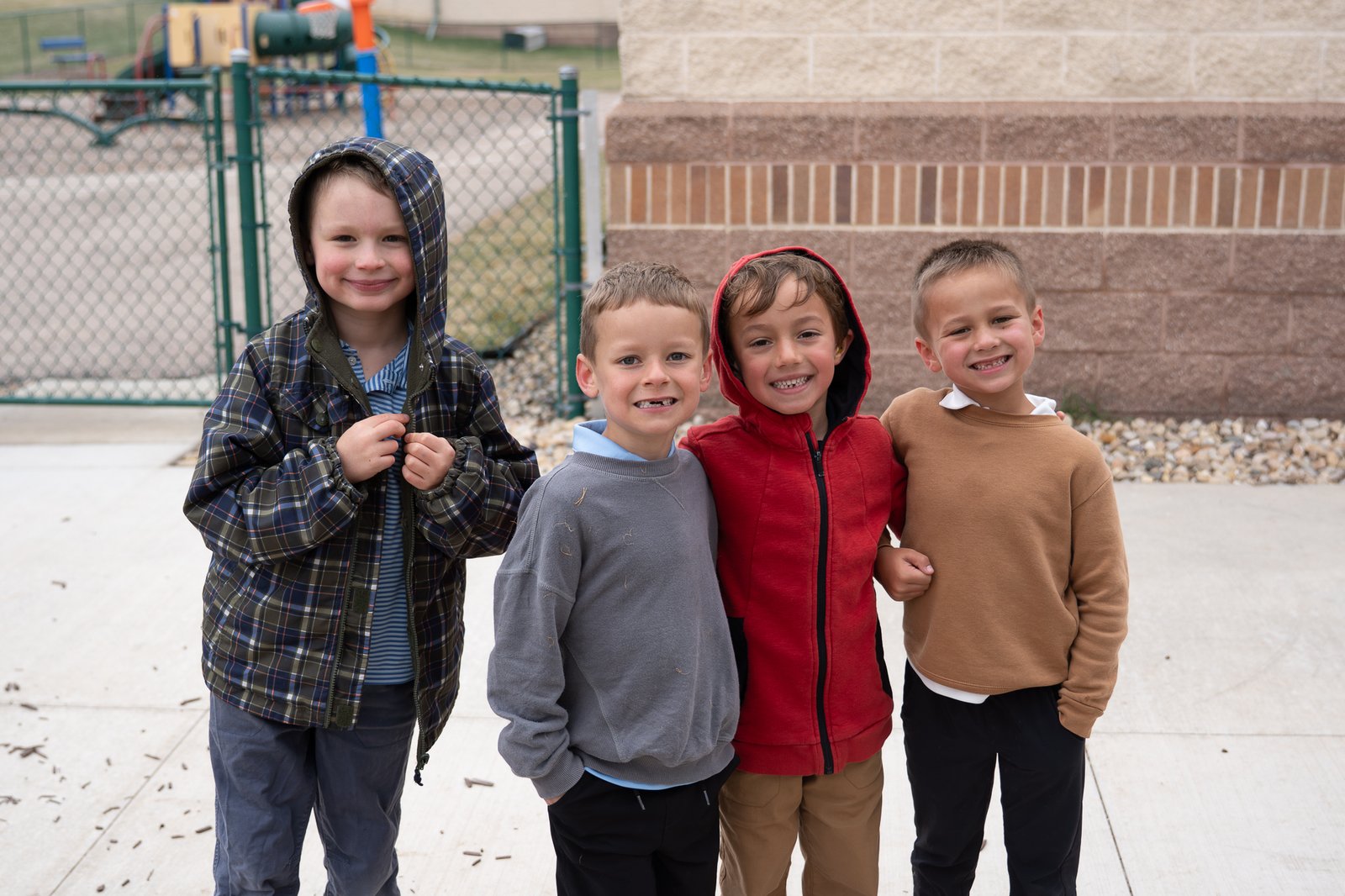 Four students with their arms around each other outside